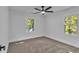 Bedroom features neutral carpet, ceiling fan, and windows offering view to the outdoors at 2358 Tilson Rd, Decatur, GA 30032