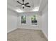 Bright bedroom with plush carpeting, ceiling fan, and windows that overlook wooded backyard at 2358 Tilson Rd, Decatur, GA 30032