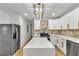 Spacious kitchen showcasing a large island, stainless steel appliances, modern lighting, and luxury vinyl plank flooring at 2358 Tilson Rd, Decatur, GA 30032