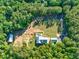 Expansive aerial view of the estate featuring a pool, barn, playground and mature trees at 2731 Tribble Mill Rd, Lawrenceville, GA 30045