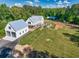 Aerial view of the farmhouse featuring a large yard, detached garage, in-ground pool, and playground at 2731 Tribble Mill Rd, Lawrenceville, GA 30045