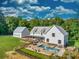 White farmhouse with metal roof, pool, detached garage, and expansive lawn at 2731 Tribble Mill Rd, Lawrenceville, GA 30045