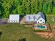 Aerial view of the estate featuring a playground, pool, and barn all surrounded by mature trees at 2731 Tribble Mill Rd, Lawrenceville, GA 30045