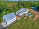Aerial view of the home, detached garage, fenced in-ground pool, large yard, and mature trees at 2731 Tribble Mill Rd, Lawrenceville, GA 30045