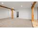 A basement view reveals wooden support beams, carpeted floors, recessed lighting, and a doorway leading to another area at 2731 Tribble Mill Rd, Lawrenceville, GA 30045