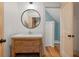 Elegant bathroom with a wooden vanity and a round mirror at 2731 Tribble Mill Rd, Lawrenceville, GA 30045