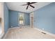 A bedroom with blue walls, carpet flooring, a ceiling fan and a window with decorative shade at 2731 Tribble Mill Rd, Lawrenceville, GA 30045