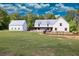 The lovely farmhouse boasts a detached garage, a sprawling lawn, and mature trees at 2731 Tribble Mill Rd, Lawrenceville, GA 30045