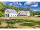 Beautiful white farmhouse with a detached garage, covered porch, and lush green lawn at 2731 Tribble Mill Rd, Lawrenceville, GA 30045