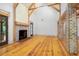 Living room with hardwood floors, exposed beams, and a brick fireplace at 2731 Tribble Mill Rd, Lawrenceville, GA 30045