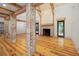 Open-concept living room featuring hardwood floors, exposed brick pillars, and a cozy fireplace at 2731 Tribble Mill Rd, Lawrenceville, GA 30045