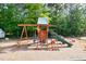 Outdoor playground featuring swings, a slide, and climbing structures, surrounded by trees and greenery at 2731 Tribble Mill Rd, Lawrenceville, GA 30045