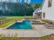 Backyard pool and spa, surrounded by lush landscaping and manicured lawns with chairs for relaxing at 2731 Tribble Mill Rd, Lawrenceville, GA 30045