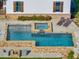 Aerial view of a backyard pool with a built-in spa, stone surround, lounge chairs, and a fire pit at 2731 Tribble Mill Rd, Lawrenceville, GA 30045