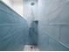 Modern shower with blue tile and a rainfall shower head at 2731 Tribble Mill Rd, Lawrenceville, GA 30045