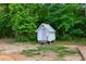 White storage shed nestled in a wooded area at 2731 Tribble Mill Rd, Lawrenceville, GA 30045