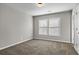 Neutral bedroom showcases natural light through shuttered windows, carpet, and a closet at 3058 Turman Cir, Decatur, GA 30033