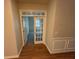 Hallway with beautiful wood flooring, glass paned door, and neutral colored walls at 7843 Nolan Trl, Snellville, GA 30039