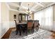 Elegant dining room with coffered ceilings, stylish chandelier, and wainscoting at 2481 Lake Erma Dr, Hampton, GA 30228