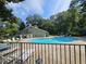 Community pool surrounded by trees, lounge chairs, and a fence on a clear day at 738 Brentwood Pl, Marietta, GA 30067