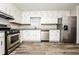 Well-lit kitchen with white cabinets, stainless steel appliances, and modern countertops offers a delightful cooking experience at 1005 Quail Dr, Stockbridge, GA 30281