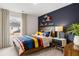 Comfortable bedroom with a modern navy accent wall and bright bedspread, creating a stylish and inviting space at 353 Sound Cir, Stockbridge, GA 30281