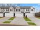 View of townhomes with modern exteriors, well-manicured lawns, driveways, and attached garages at 353 Sound Cir, Stockbridge, GA 30281