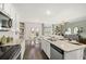 Open-concept kitchen with stainless steel appliances, granite island, dining area, and living room at 353 Sound Cir, Stockbridge, GA 30281