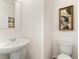 Well-lit powder room featuring a pedestal sink and toilet, providing a convenient and stylish space for guests at 353 Sound Cir, Stockbridge, GA 30281