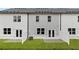 Backyard view of townhomes featuring a lawn, patios, and partial fencing for privacy at 353 Sound Cir, Stockbridge, GA 30281