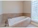 Bathroom with a large, modern jetted tub and glass block window at 2612 Cliffview Dr, Lilburn, GA 30047