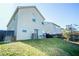 View of the home's back exterior, featuring a sloped yard, patio area, and fenced boundary at 264 Magnaview Dr, Mcdonough, GA 30253