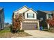 Two-story home featuring tan siding, brick accents, a two-car garage, and a well-manicured front yard at 264 Magnaview Dr, Mcdonough, GA 30253
