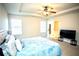 Large carpeted bedroom includes a tray ceiling, ceiling fan, and two windows at 264 Magnaview Dr, Mcdonough, GA 30253