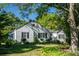 Charming white house with black shutters, landscaped yard, and mature trees at 5154 Central Dr, Stone Mountain, GA 30083