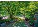 Landscaped garden with lush greenery, stone pathway, and various plants at 5154 Central Dr, Stone Mountain, GA 30083