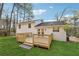 Home features a well-maintained backyard with a wood deck and lush greenery at 3302 Mixon Way, Stone Mountain, GA 30087
