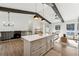 Open concept kitchen with island, white cabinets, and stainless steel appliances at 3302 Mixon Way, Stone Mountain, GA 30087