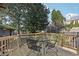 Back deck featuring wood railing, outdoor seating, and mature trees at 3930 Peachtree Dunwoody Ne Rd, Atlanta, GA 30342
