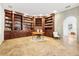 Home office features travertine floors, classic wood-paneled shelves, and a comfortable workspace at 3930 Peachtree Dunwoody Ne Rd, Atlanta, GA 30342