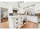 Kitchen with white cabinetry, a large island with drawers, stainless appliances, and views into the living area at 3930 Peachtree Dunwoody Ne Rd, Atlanta, GA 30342