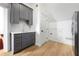 Kitchenette featuring gray cabinets, stainless steel appliances, gold hardware and light wood floors at 3930 Peachtree Dunwoody Ne Rd, Atlanta, GA 30342