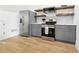 Kitchenette features stainless steel appliances, gray cabinets and floating shelves at 3930 Peachtree Dunwoody Ne Rd, Atlanta, GA 30342