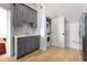 Laundry area with gray shaker cabinets, modern gold hardware and a stacked washer and dryer at 3930 Peachtree Dunwoody Ne Rd, Atlanta, GA 30342