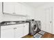 Well-lit laundry room featuring modern washer and dryer, plus ample cabinet space at 3930 Peachtree Dunwoody Ne Rd, Atlanta, GA 30342