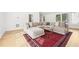 Open living room with wood floors, a large rug, a sectional sofa, and lots of natural light at 3930 Peachtree Dunwoody Ne Rd, Atlanta, GA 30342