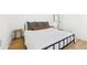 Minimalist main bedroom with a black metal bedframe, light wood flooring and a natural fiber side table at 3930 Peachtree Dunwoody Ne Rd, Atlanta, GA 30342