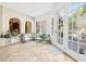 Bright sun room features travertine floors, white brick accents, and large windows overlooking a pool at 3930 Peachtree Dunwoody Ne Rd, Atlanta, GA 30342