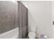 Clean bathroom with a shower-tub combination and neutral tile and grey curtain at 3695 Townley Ln, Cumming, GA 30040