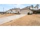 A single-story home is accompanied by a long driveway and well-kept lawn in a suburban setting at 3695 Townley Ln, Cumming, GA 30040